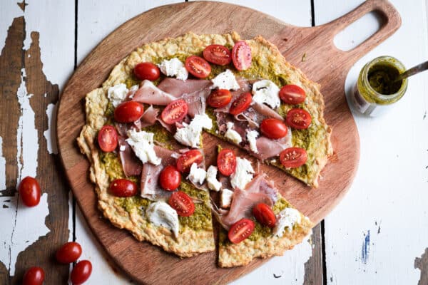pizza med pesto, skinke, mozzarella og tomater